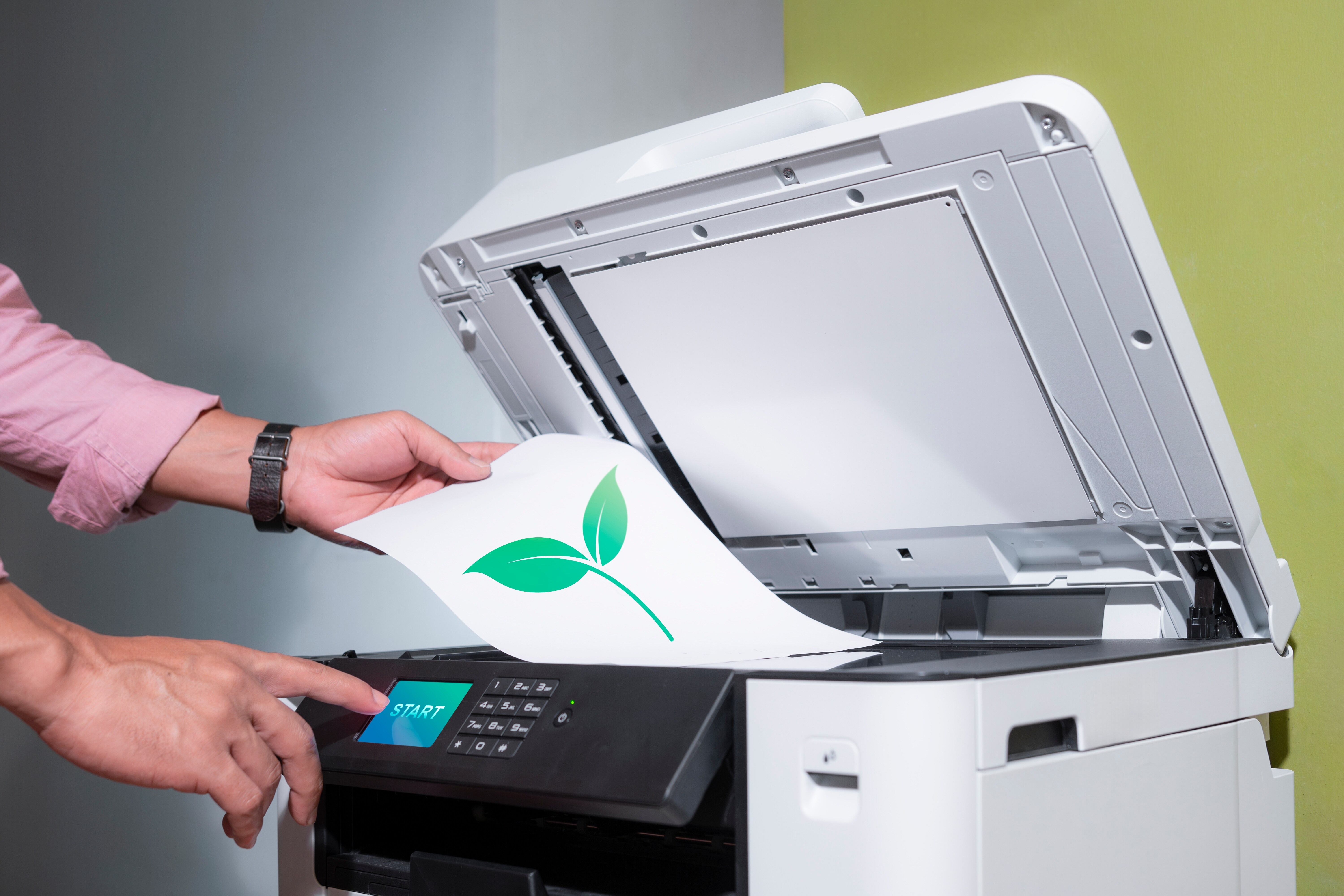 Sustainable Printing resized Image of someone putting a paper into a printer