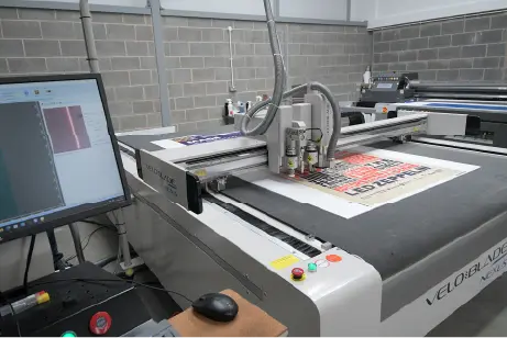 A piece of print being trimmed on a professional guillotine